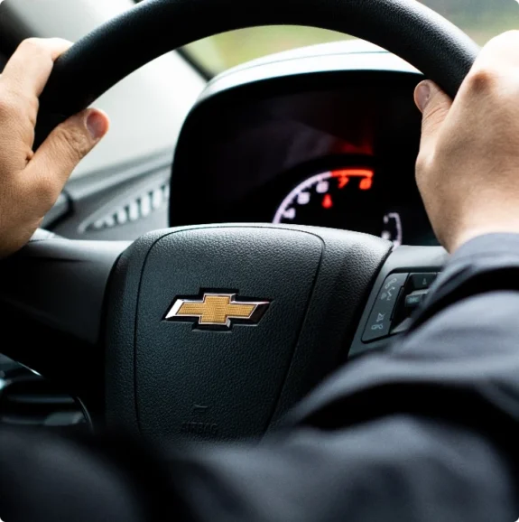 Närbild på Chevrolet-ratt under körning – bilverkstad Huskvarna servar GM-bilar.